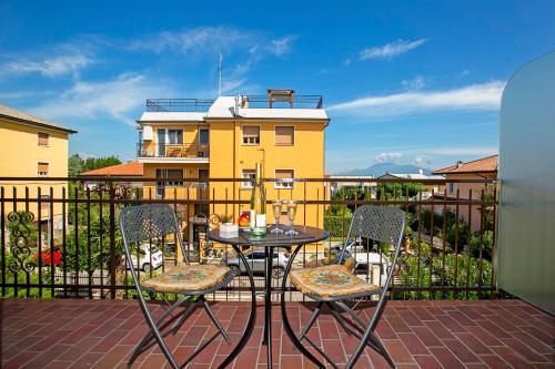 um pátio com uma mesa e cadeiras numa varanda em Villa Mimosa - Appartamento 2 - Happy Rentals em Desenzano del Garda