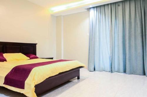 a bedroom with a bed and a large window at City View No 5, Mawanda Road. in Kampala