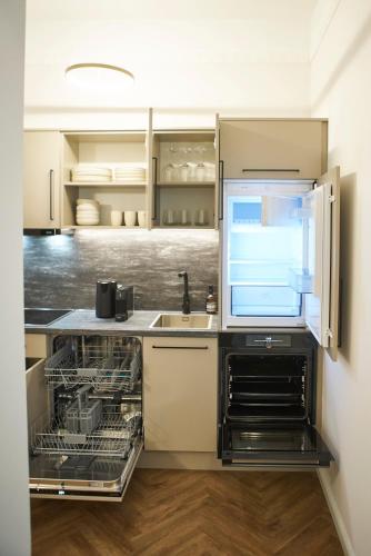 a kitchen with an open dishwasher next to a sink at Nove Boutique Apartments in Vienna