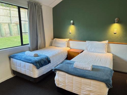 オークランドにあるオークウッド マナー モーター ロッジのベッド2台と窓が備わる客室です。