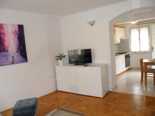 a living room with a tv on a white cabinet at Arco Arina Apartment in Pula