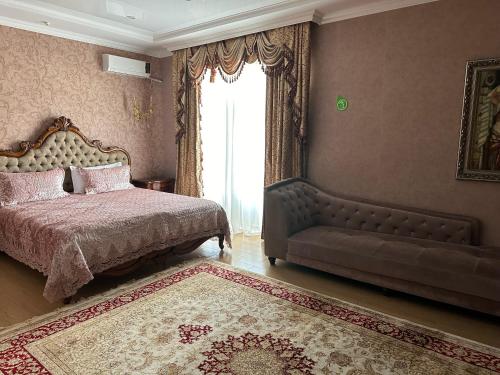 um quarto com uma cama, um sofá e uma janela em Royal em Aqtöbe