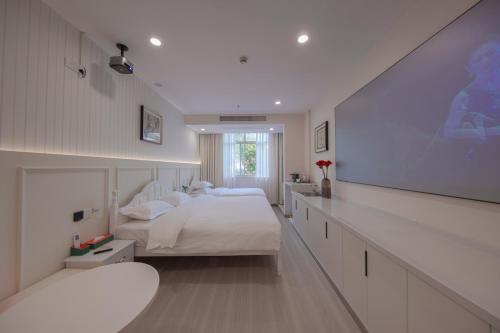 a bedroom with two beds and a flat screen tv at Orient Rose International Hotel in Shanghai