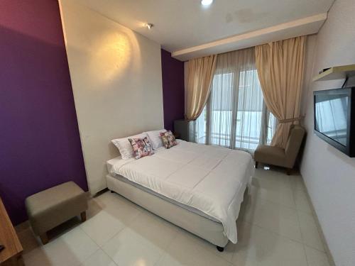 a small bedroom with a bed and a tv at ANNIE KUCA in Jakarta