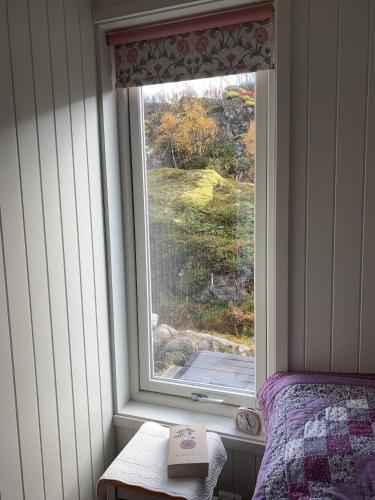 a window in a room with a bed and a book at Unique private cabin in Lofoten in Leknes