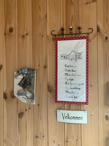 a sign is hanging on a wooden wall at Unique private cabin in Lofoten in Leknes