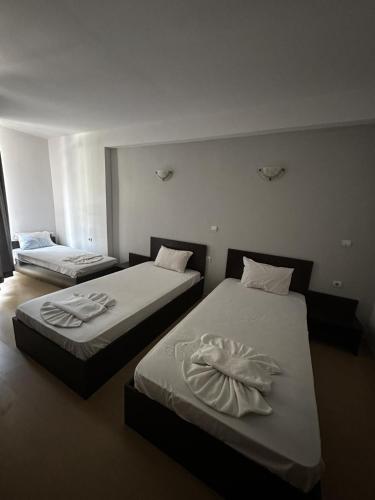two beds in a hotel room with two bedsvisor at Хотел Костенец in Kostenets