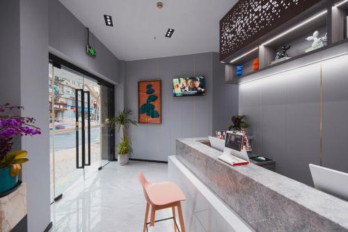a lobby with a counter and a pink chair at Orient Rose International Hotel in Shanghai