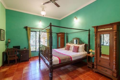 Schlafzimmer mit Himmelbett und grünen Wänden in der Unterkunft Vintage Estate - Lakeside allure with vintage decor,A plunge pool & A lawn featuring a charming gazebo in Karjat