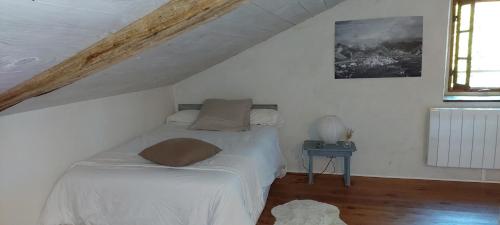 a small bedroom with a bed in a attic at Haou de campagne in Peyre