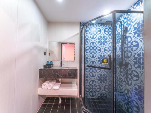 a bathroom with a shower and a sink at Wind sleeping Color Hotel - GuangZhou CHIME LONG Line7&18Nancun Wanbo STN in Guangzhou