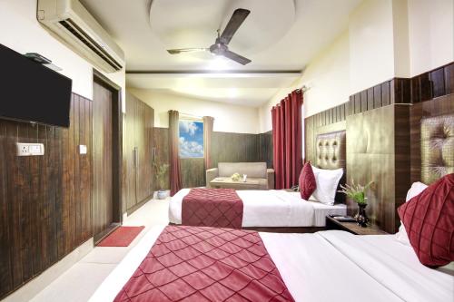una camera d'albergo con due letti e una televisione di RTS Hotel Delhi Airport a Nuova Delhi