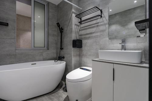 a bathroom with a toilet and a sink and a bath tub at Deluxe One-bedroom Apartment Black and White Gray Modern Style Designer Brand Central Air Conditioning in Shanghai