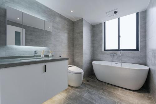 ein Badezimmer mit einer weißen Badewanne und einem Waschbecken in der Unterkunft Modern Light Luxurious Three-bedroom Apartment Lazy Afternoon Cozy Sun from Zhongshan Park Metro Station 200m in Shanghai