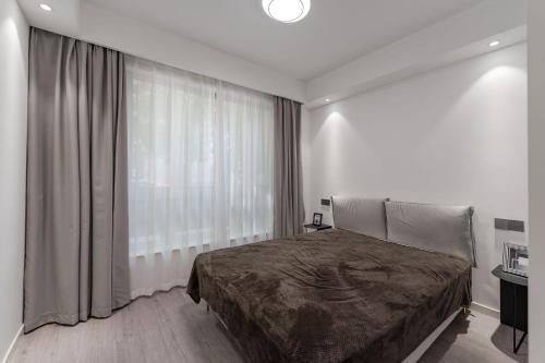 a bedroom with a bed and a large window at Deluxe One-bedroom Apartment Black and White Gray Modern Style Designer Brand Central Air Conditioning in Shanghai