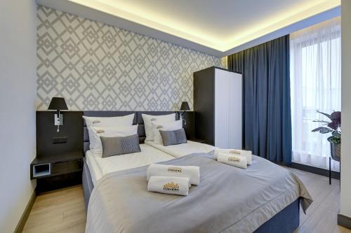 a bedroom with two beds with white pillows on them at Downtown Apartments Riverside Szafarnia Street in Gdańsk