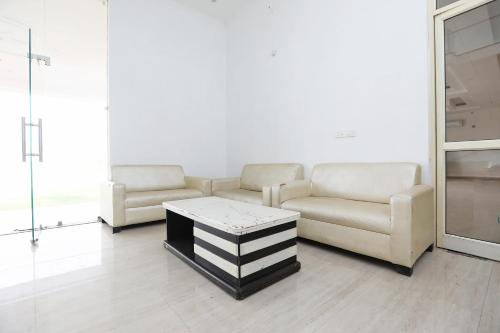 ein Wohnzimmer mit 2 Sofas und einem Couchtisch in der Unterkunft OYO Diamond Resort in Alwar
