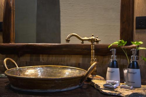 een wastafel in de badkamer met een koperen bad en een spiegel bij Dream Cliff Mountain Resort in Haputale