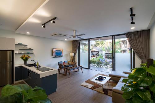 uma cozinha e sala de estar com um sofá e uma mesa em Beach Haven Suites Hội An Apartment em Hoi An
