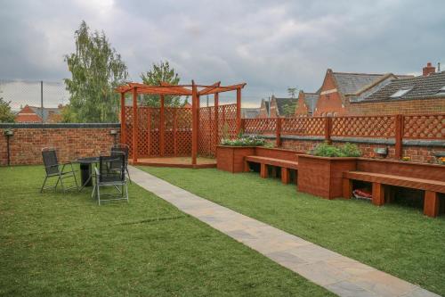 a garden with benches and a gazebo at Oscar Lodge in Northampton