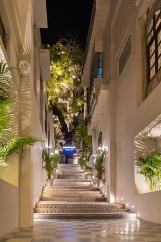 a hallway of a building with stairs and plants at Manuscript - Jhilwara Haveli in Udaipur