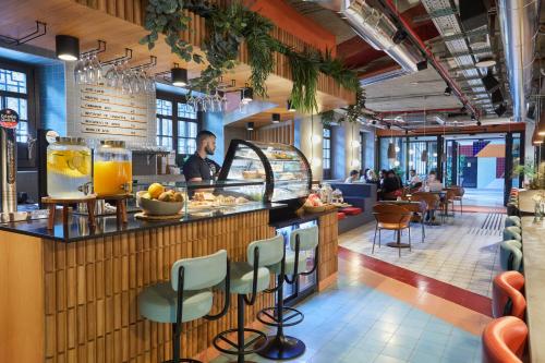 a man standing at a bar in a restaurant at The Social Hub Madrid 4 star in Madrid