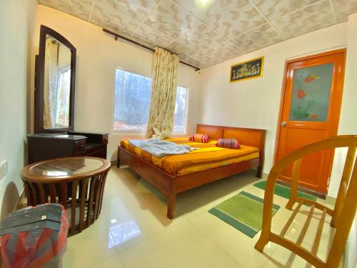 ein Schlafzimmer mit einem Bett und einem Tisch und einem Fenster in der Unterkunft Lakshan View Resort in Haputale
