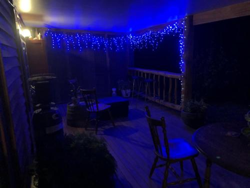 Yea的住宿－Starlight Lodge，露台配有蓝色的灯光和椅子以及桌子