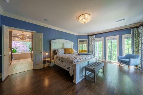 a bedroom with a bed and a blue wall at Lakeside Paradise - Luxury by the lake in Afton