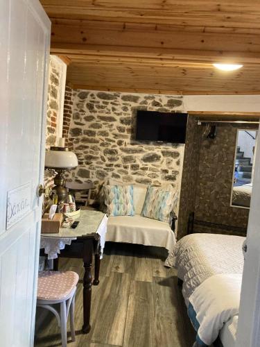 a bedroom with two beds and a stone wall at Old Town Traditional Residence in Kavala