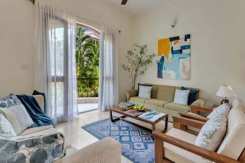 a living room with a couch and a table at Aguada Anchorage - The Villa Resort, Candolim in Candolim