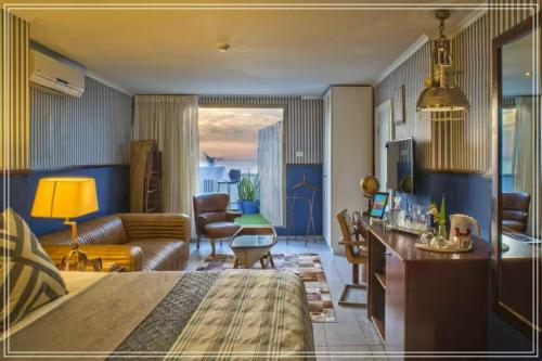 um quarto de hotel com uma cama e uma sala de estar em Bugrashov Beach 88 Hotel And Spa em Tel Aviv