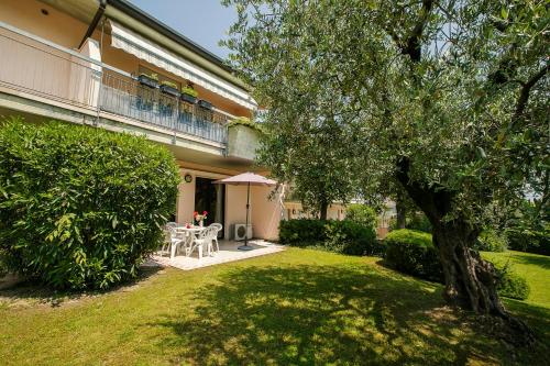 een huis met een tuin met een tafel en een boom bij Casa Kristall Lago - Happy Rentals in Desenzano del Garda