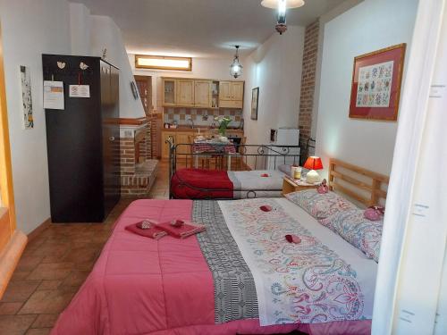 a bedroom with a large bed with a pink blanket at L'arancio Antico in Iglesias