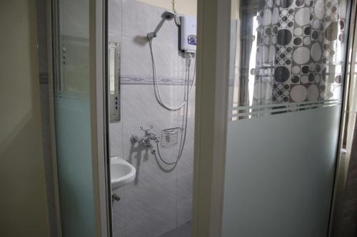 y baño con ducha y lavamanos. en Apollo Inn Fortportal, en Kigarama