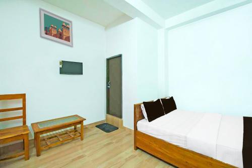a bedroom with a bed and a table and a television at OYO Assam Inn Grand in Guwahati
