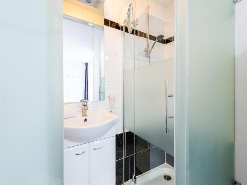 uma casa de banho branca com um lavatório e um espelho em Exclusive ski-in & ski-out apartment in Ellmau em Ellmau
