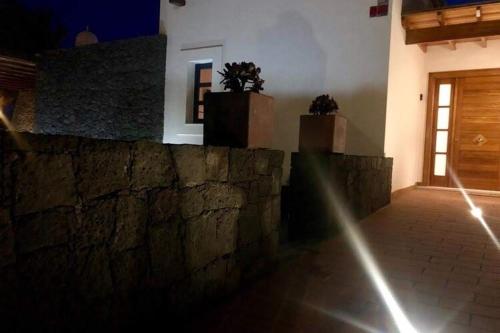 a stone wall with two potted plants on top of it at Beautiful holiday home in Playa Blanca with pool in Playa Blanca