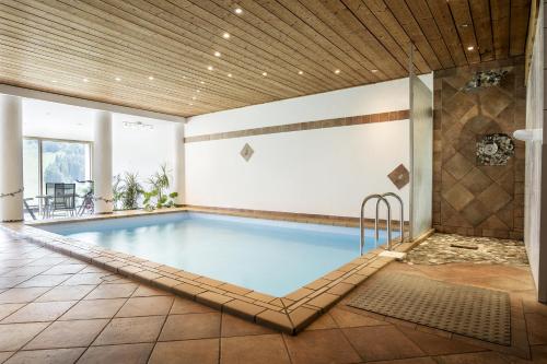 einen Pool in einem Gebäude mit Fliesenboden in der Unterkunft Villa Valluga in Mittelberg
