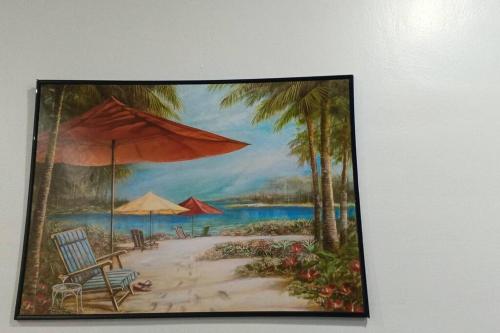 una pintura de una playa con sillas y sombrillas en Kings' Palms Residence04, en General Santos