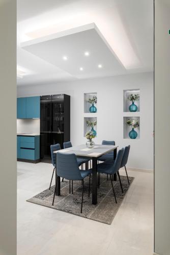 a dining room with a table and blue chairs at Modern & Stylish Apartment Close to Tigne Point - Close to Saint Julians & Valletta Ferry in Sliema