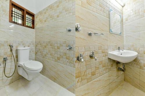 a bathroom with a toilet and a sink at Malabar Plaza INN in Cochin