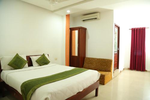 a bedroom with a bed and a chair in it at Malabar Plaza INN in Cochin