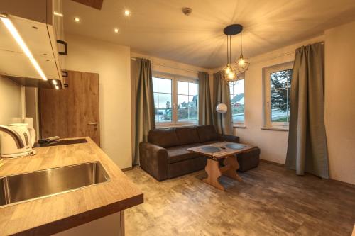 ein Wohnzimmer mit einem Sofa und einem Tisch in der Unterkunft Haus Susanne in Oberhof