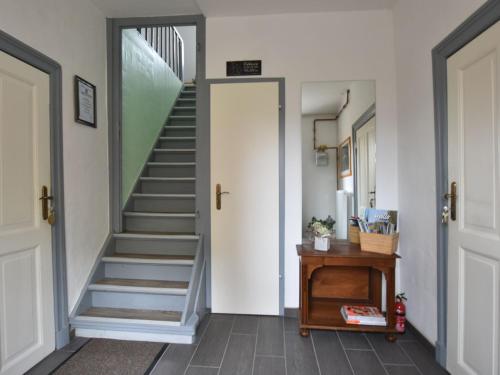 einen Flur mit einer Treppe und eine Tür mit einem Tisch in der Unterkunft Lavish Apartment in Kl tz with Beach nearby in Klütz