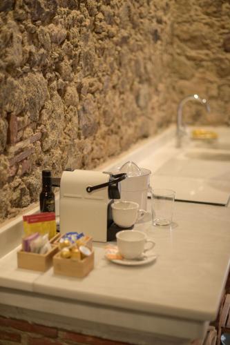 a counter with a coffee maker and cups on it at Apartamentos Alojería Béjar in Béjar