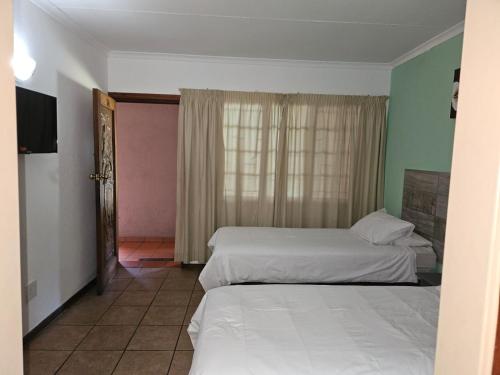 Voodi või voodid majutusasutuse Rustenburg Palm Lodge toas