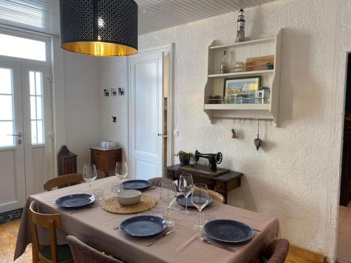 uma mesa de jantar com pratos e copos de vinho em Villa Soulacaise Plage et Centre em Soulac-sur-Mer