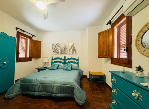 1 dormitorio con 1 cama azul y vestidor azul en La maison sul mare, en San Vito lo Capo