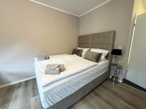 een slaapkamer met een groot bed met witte lakens en kussens bij City Spot Zimmer24Frei in Köln in Keulen